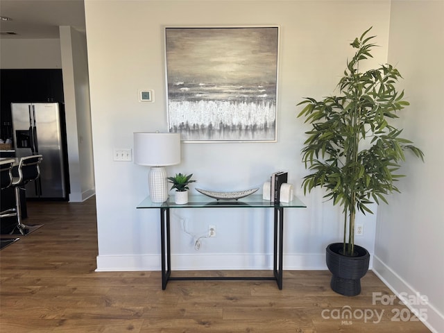 interior space featuring stainless steel refrigerator with ice dispenser and wood-type flooring