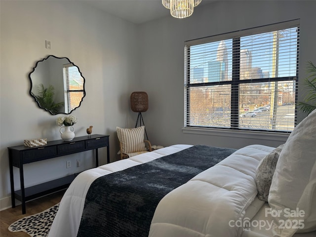 bedroom with wood-type flooring and a notable chandelier