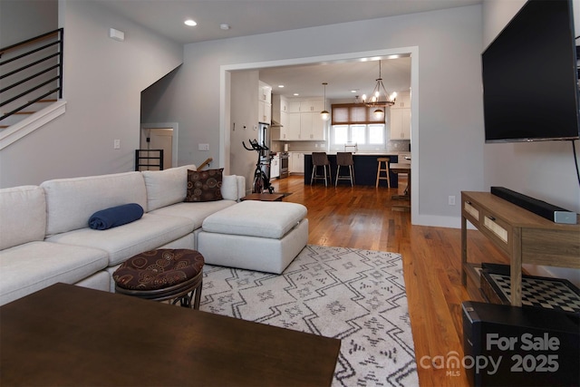 living room featuring an inviting chandelier and light hardwood / wood-style flooring