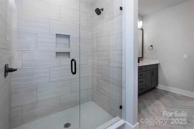 bathroom with vanity, an enclosed shower, and parquet flooring