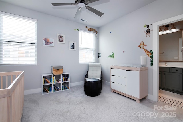 carpeted bedroom featuring ceiling fan, ensuite bath, and sink