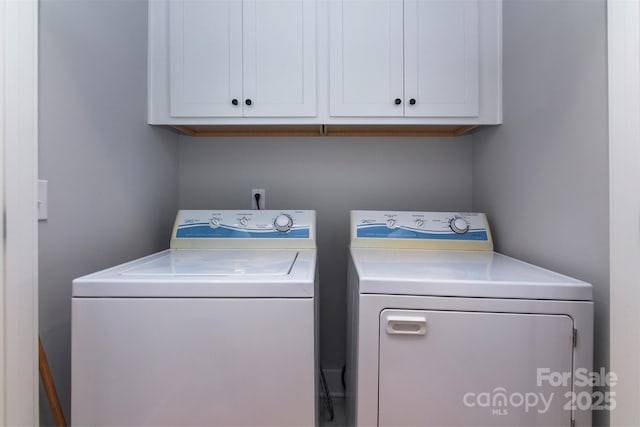 washroom with cabinets and washer and dryer