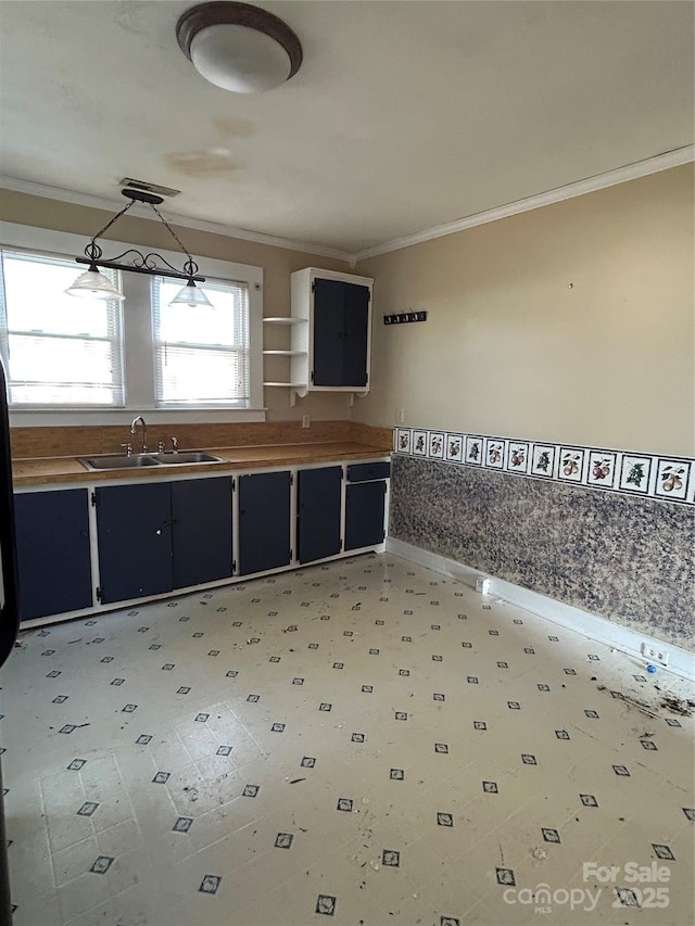 kitchen with sink, pendant lighting, and ornamental molding