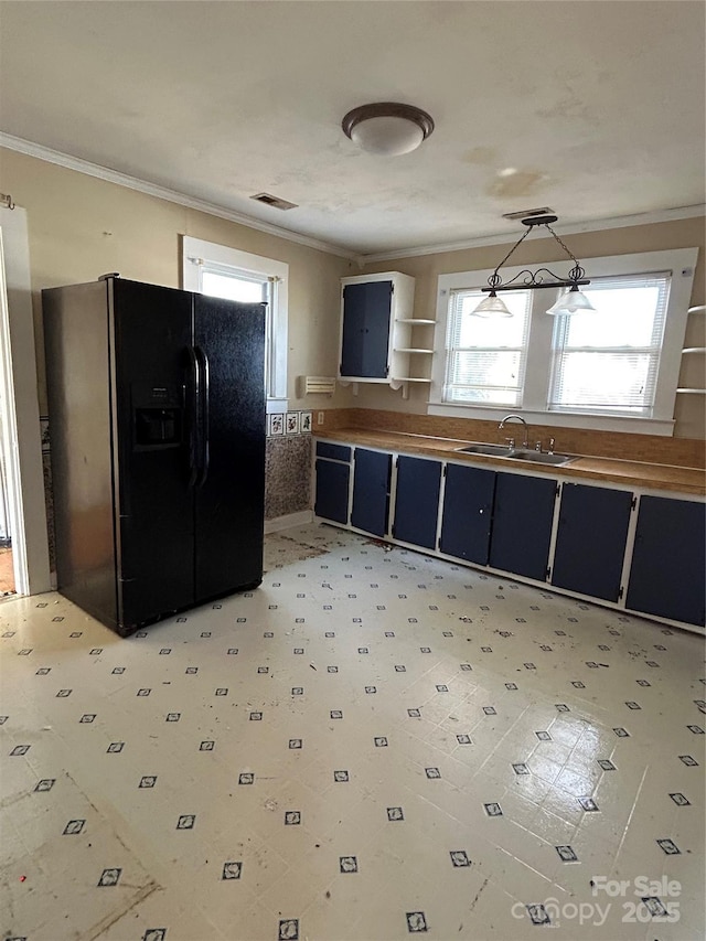 kitchen featuring black fridge with ice dispenser, decorative light fixtures, crown molding, and sink