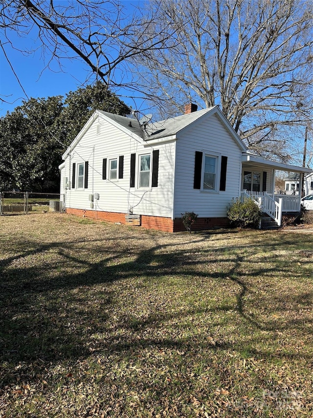 view of home's exterior with a yard and a porch