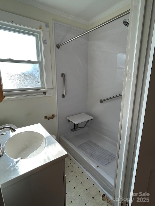 bathroom with vanity, ornamental molding, and walk in shower