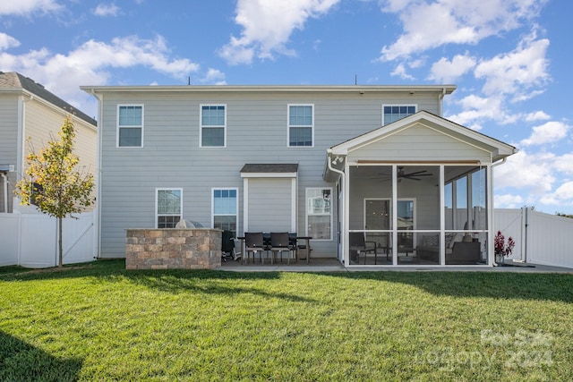 rear view of house featuring a lawn, a patio area, a sunroom, and ceiling fan