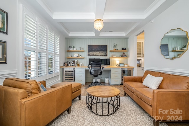 living room featuring crown molding, beverage cooler, built in desk, and light wood-type flooring