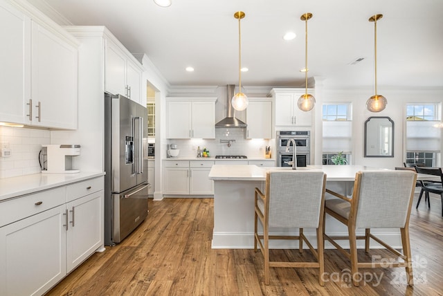 kitchen featuring wall chimney exhaust hood, white cabinetry, and stainless steel appliances