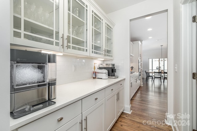 kitchen with tasteful backsplash, white cabinetry, and dark hardwood / wood-style floors