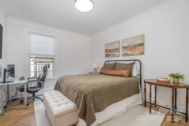 bedroom with light hardwood / wood-style floors and crown molding