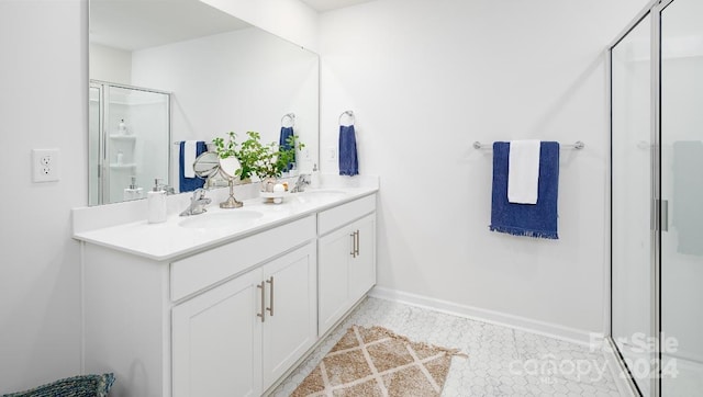 bathroom with a shower with door, vanity, and tile patterned floors