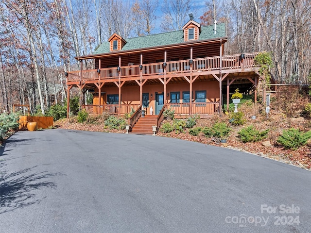 log home featuring covered porch