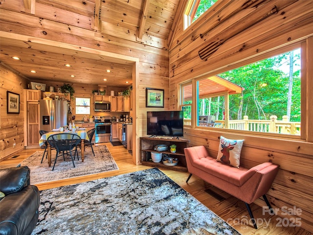 living room with wood ceiling, light hardwood / wood-style flooring, and wood walls