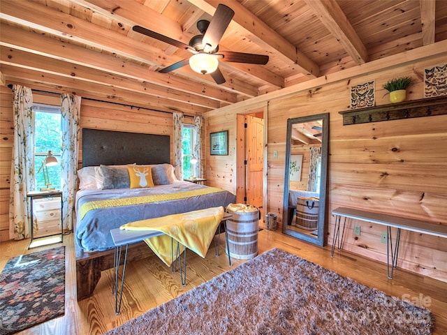 bedroom featuring beamed ceiling, wood ceiling, wooden walls, and light hardwood / wood-style floors