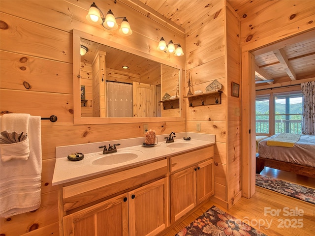 bathroom featuring hardwood / wood-style floors, wooden walls, beamed ceiling, vanity, and wood ceiling