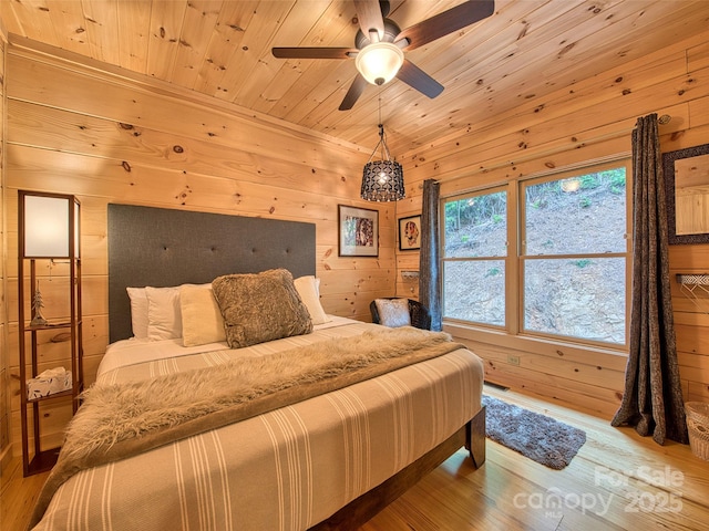 bedroom with wood-type flooring, wooden ceiling, and wood walls