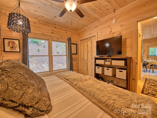 bedroom featuring wood walls, a closet, and wooden ceiling