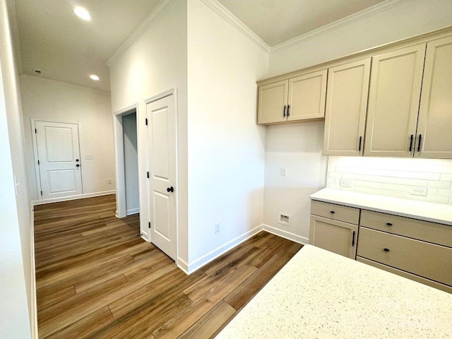 kitchen with cream cabinets, crown molding, tasteful backsplash, and wood-type flooring