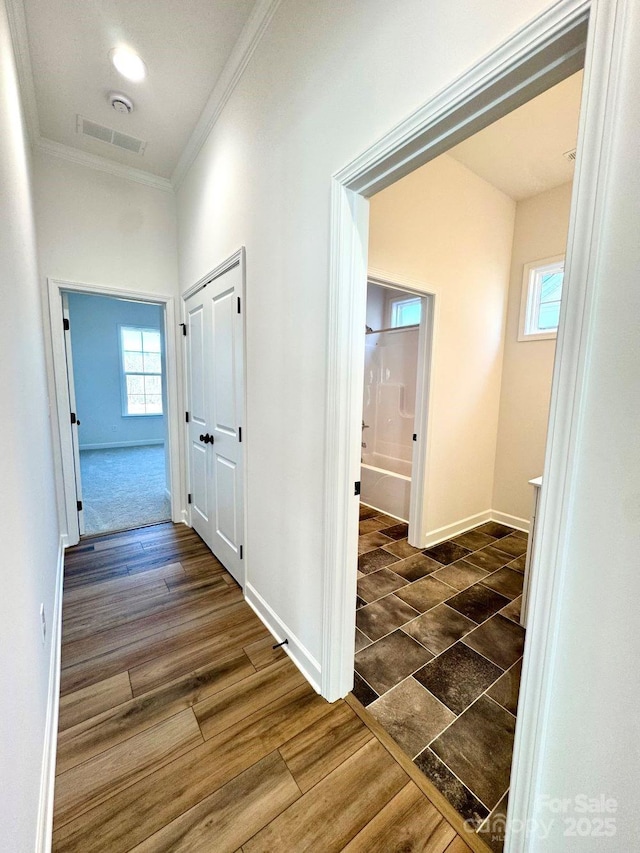 hallway with ornamental molding and dark hardwood / wood-style flooring