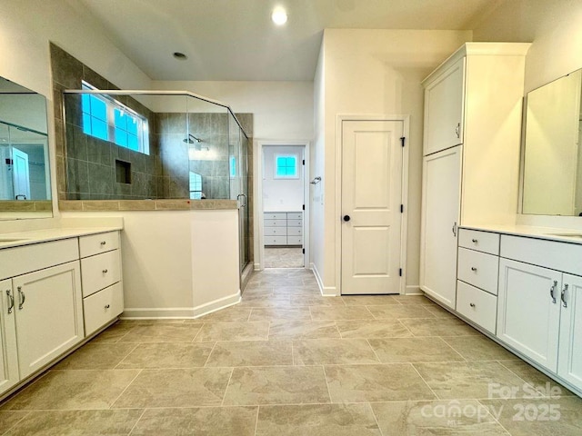 bathroom with a shower with shower door and vanity