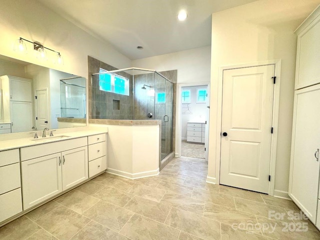 bathroom featuring a shower with shower door, a wealth of natural light, and vanity