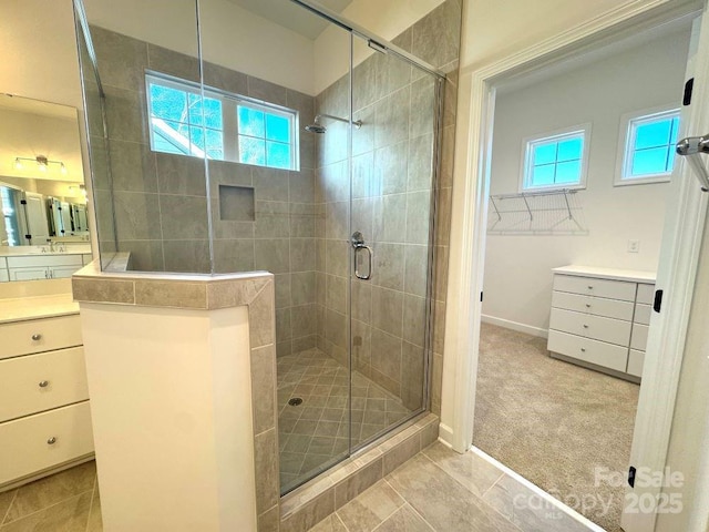 bathroom featuring a shower with door, a wealth of natural light, and vanity