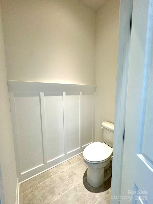 bathroom with toilet and tile patterned flooring