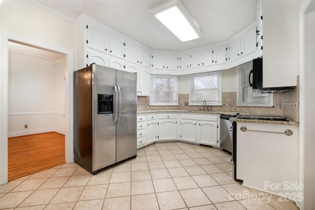 kitchen featuring stainless steel refrigerator with ice dispenser, tasteful backsplash, sink, light tile patterned floors, and white cabinets