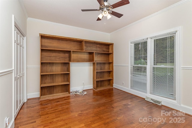 unfurnished bedroom with ornamental molding, wood finished floors, visible vents, and baseboards