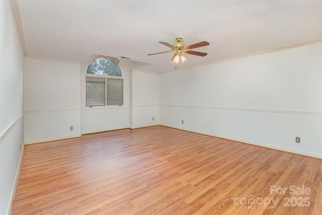 empty room with crown molding, baseboards, light wood-style flooring, and a ceiling fan