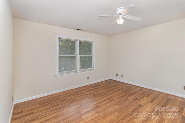 unfurnished room featuring visible vents, baseboards, ceiling fan, and wood finished floors