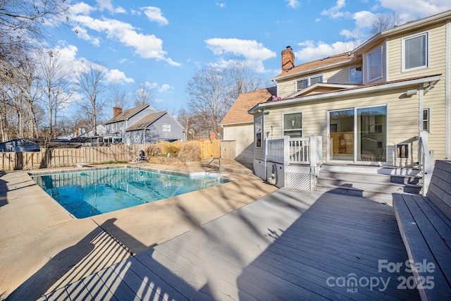 view of swimming pool featuring a deck, a patio, fence, and a fenced in pool