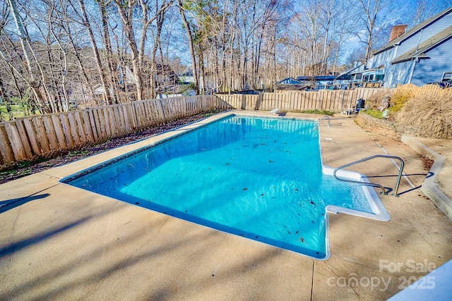 view of swimming pool featuring a fenced in pool, a fenced backyard, and a patio