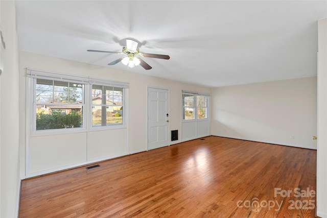 empty room with hardwood / wood-style floors and ceiling fan