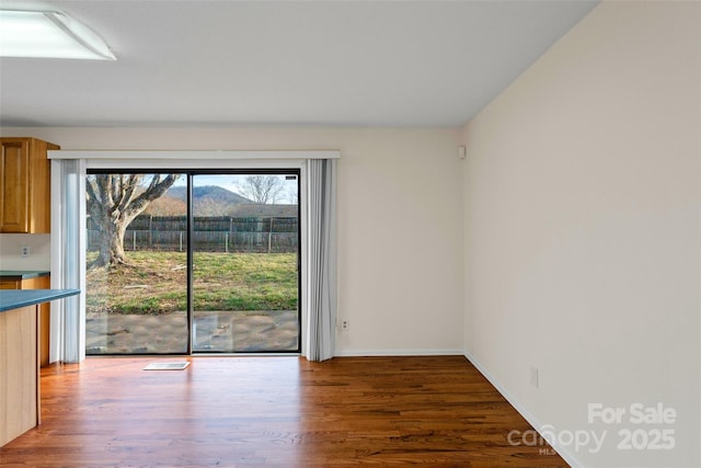 unfurnished dining area featuring dark wood-type flooring