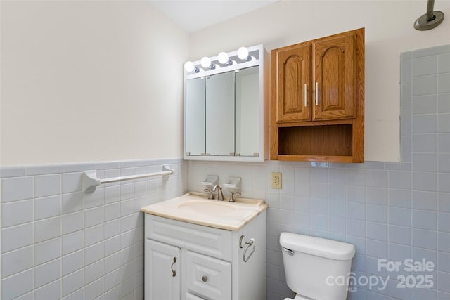 bathroom featuring vanity, toilet, and tile walls