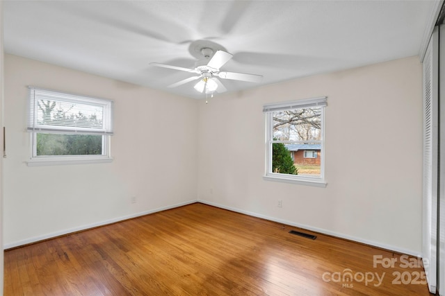 empty room with wood-type flooring and ceiling fan