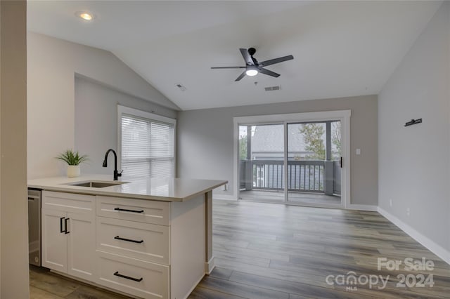 kitchen featuring white cabinetry, sink, lofted ceiling, and light wood-type flooring