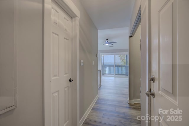 hallway featuring baseboards and wood finished floors