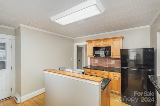 kitchen featuring decorative backsplash, ornamental molding, black appliances, a center island, and light hardwood / wood-style floors