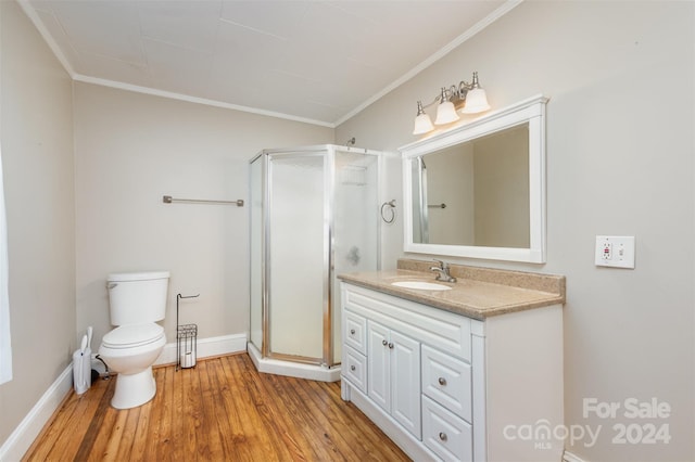 bathroom with vanity, a shower with door, crown molding, hardwood / wood-style flooring, and toilet