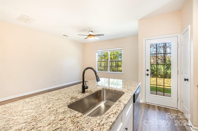 kitchen featuring light stone countertops, stainless steel dishwasher, sink, dark hardwood / wood-style floors, and white cabinetry