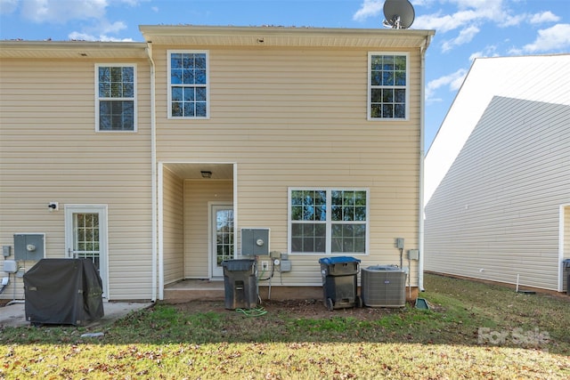 rear view of property with a yard, a patio, and central AC unit