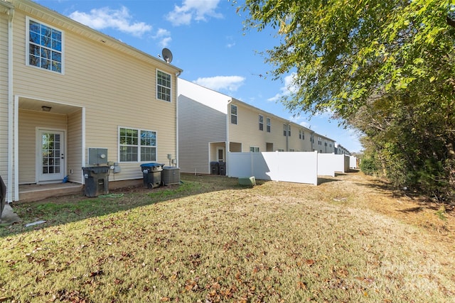 rear view of house with a yard and central AC unit