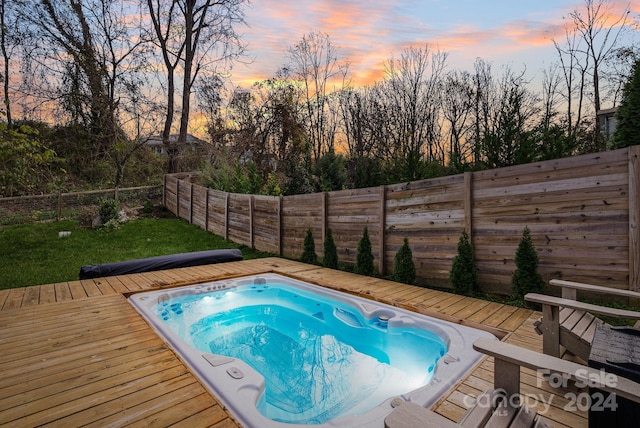 pool at dusk featuring a deck