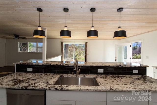 kitchen featuring dishwasher, sink, light stone countertops, decorative light fixtures, and white cabinetry