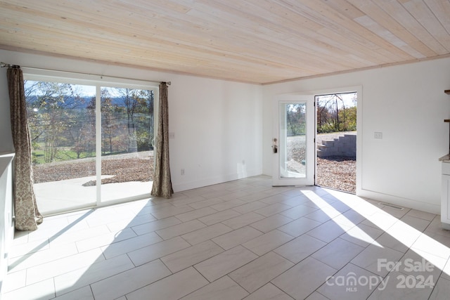 empty room featuring wooden ceiling and light tile patterned floors