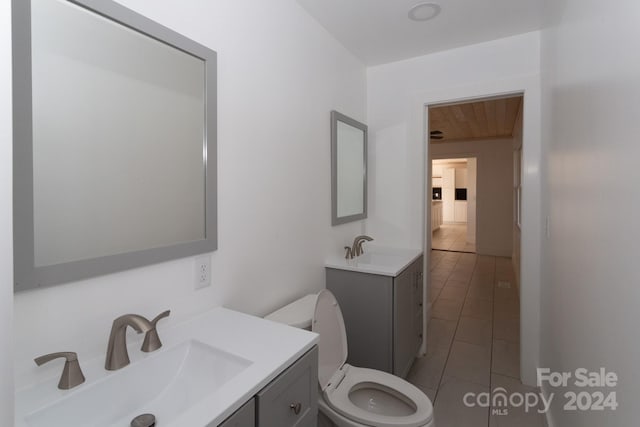 bathroom featuring tile patterned floors, vanity, and toilet