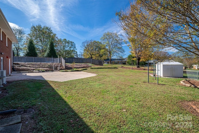 view of yard with a storage unit and a patio area